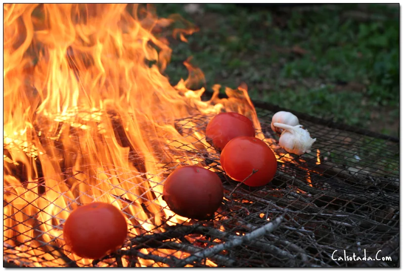 Tomates y ajos al fuego para preparar la salsa de calçots
